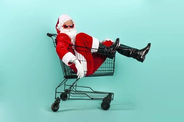 Santa Claus Shopper Okularach Przeciwsłonecznych Garnitur Siedzi Pustym Koszyku Niebieskim — Zdjęcie stockowe