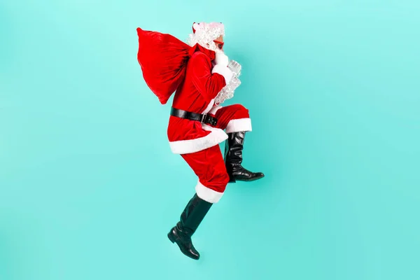 贈り物の袋が付いているサンタクロースはジャンプし 青い隔離された背景ですぐに空気で動き サンタは飛び 新年のために急ぎ クリスマス — ストック写真