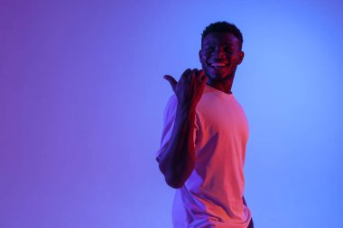 Afro-Amerikan adam elini neon ışıkta tekrar gösteriyor, adam fotokopi alanının reklamını arkadan yapıyor.