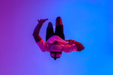 Sanal gerçeklik gözlüklü Afro-Amerikan bir adam havada süzülüyor ve neon ışıklarıyla havaya düşüyor, adam VR gözlükleriyle uçuyor, fantezi ve hayal gücü kavramı