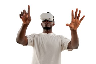 Afrikalı Amerikalı bir adam sanal gerçeklik gözlükleriyle video oyunları oynar ve beyaz izole edilmiş arka planda eliyle dokunur. Adam VR gözlükleriyle yan tarafa bakar ve parmağıyla işaret eder.