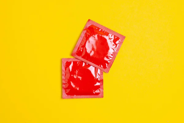Deux Préservatifs Rouges Reposent Sur Fond Jaune Concept Sexe Sans — Photo