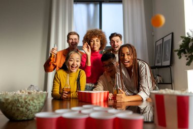 Bira pong oynayan ve ev partisinde bira içen çok ırklı bir grup genç öğrenci. Afrikalı Amerikalı kız nişan alıyor ve top fırlatıyor.