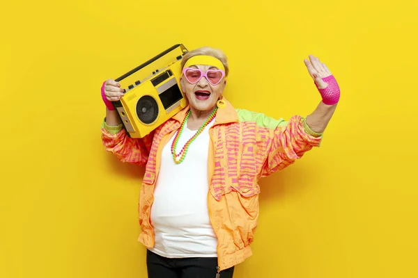 할머니 스포츠 힙스터 테이프 레코더 노란색 배경에 온라인 셀카를 여자는 스톡 사진