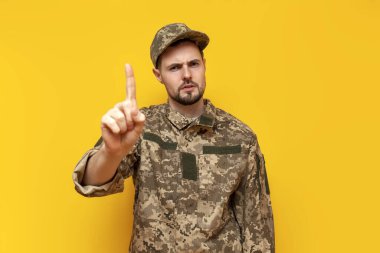 Kamuflaj piksel üniformalı genç Ukraynalı erkek asker, Ukrayna ordusunun askeri öğrencilerinin sarı izole bir geçmişi olduğu konusunda uyardı ve tehdit etti.