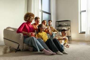 Çok ırklı bir grup genç arkadaş evde kanepede oturup bira içiyor ve televizyon seyrediyor, alkol içiyor, patlamış mısır yiyor ve rahatlıyor.