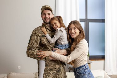 Ukrayna ordusunun genç askeri kamuflaj üniforması içinde evine, ailesine döndü. Bir asker, küçük kızına ve karısına evde sarıldı.