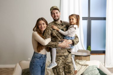 Ukrayna ordusunun genç askeri kamuflaj üniforması içinde evine, ailesine döndü. Bir asker, küçük kızına ve karısına evde sarıldı.