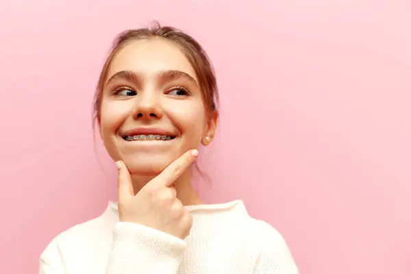 Nachdenkliche Teenager Mädchen Mit Zahnspange Pläne Und Denkt Während Sie lizenzfreie Stockbilder