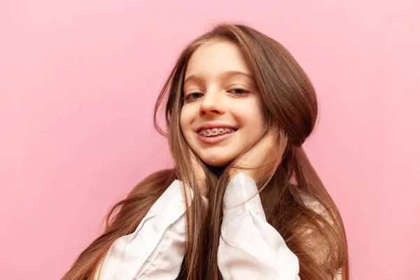 Mała Nastolatka Aparatem Zębach Uśmiechnięta Trzymająca Długie Włosy Różowym Odizolowanym Zdjęcie Stockowe