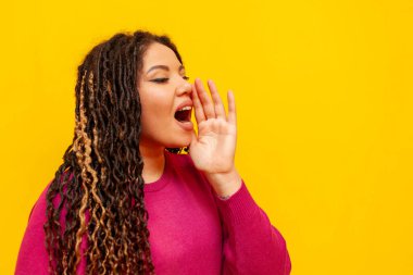 Sarı izole bir arka planda rastalı anonsları ve bağırışları olan tombul Afrikalı Amerikalı kadın, at kuyruklu iri yarı bir kız yüksek sesle konuşur ve reklamlar yapar.