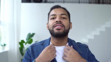 Kendinden emin Afro-Amerikalı adam evden çıkmaya hazırlanıyor ve aynaya bakıyor, diş telleri olan yetişkin adam saçını düzeltiyor ve aynada gülümsüyor.
