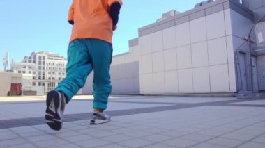 Genç akrobatik adam şehirde takla atıp dans ediyor, enerjik çılgın adam jimnastik numaralar yapıyor ve sokakta serbest stil gösteriyor.