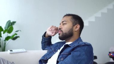 Düşünceli Afrikalı Amerikalı adam evinde oturuyor ve hayaller kuruyor, planlar kuruyor, kendinden emin olmayan adam seçiyor ve düşünüyor.