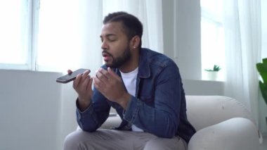 Öfkeli Afro-Amerikalı adam evde telefonla bağırıyor ve tartışıyor. Tatminsiz adam çatışma yaşıyor ve akıllı telefondan konuşuyor.