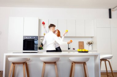 Genç aşıklar dans ediyor ve yeni mutfağımızda kutlama yapıyorlar. Kız ve erkek kiralık dairede birlikte eğleniyorlar.