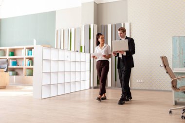 İş toplantısındaki iş adamları, ofis çalışanları ve iş adamları internet istatistiklerini analiz etmek için dizüstü bilgisayar kullanan Afro-Amerikan kadın ve Avrupalı genç adam.