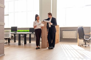 İş adamı kılığındaki genç adam rapor okuyor ve ofisteki Afrikalı Amerikalı bayan patronla konuşuyor, ofis çalışanları ve meslektaşları gazetelerle iletişim kuruyor ve birlikte çalışıyorlar.