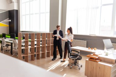 İş adamı kılığındaki genç adam rapor okuyor ve ofisteki Afrikalı Amerikalı bayan patronla konuşuyor, ofis çalışanları ve meslektaşları gazetelerle iletişim kuruyor ve birlikte çalışıyorlar.