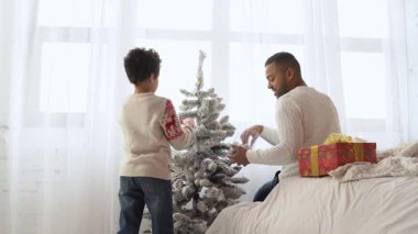 Yeni yılda oğluyla birlikte Afrika kökenli Amerikalı bir adam Noel ağacını oyuncaklarla süslüyor ve Noel 'i evde kutluyor. Babası çocuğun yeni yıl atmosferini hazırlamasına yardım ediyor.