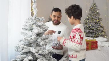 Yeni yılda oğluyla birlikte Afrika kökenli Amerikalı bir adam Noel ağacını oyuncaklarla süslüyor ve Noel 'i evde kutluyor. Babası çocuğun yeni yıl atmosferini hazırlamasına yardım ediyor.