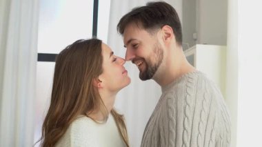 Genç bir çift kanepede sarılıyor ve konuşuyor, mutlu bir adam ve kadın ilişki içinde, konuşuyor ve öpüşüyor, yakın plan.