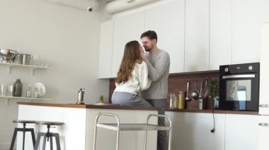 Genç çift sabah mutfakta sarılır ve kahve yapar, karı koca birlikte sevinir ve evde ocağın yanında dans ederler.