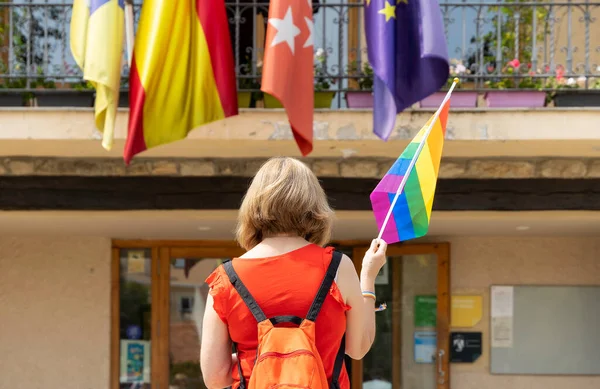 政府の建物の前に一人で立っている女性が虹の旗を掲げている 権利の概念のための戦い — ストック写真