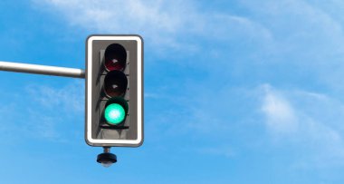 Yeşil ışıkta trafik ışığı, mavi gökyüzü ve arka planda bulutlar. Boşluğu kopyala