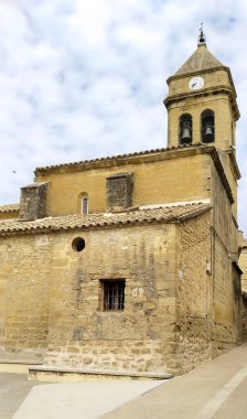 Saat kulesi ve penceresi olan bir ortaçağ kilisesi. Binanın eski ve dış yüzeyi taş gibi.