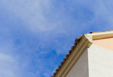 Kiremit çatılı ve beyaz duvarlı mavi bir gökyüzü. Boşluğu kopyala