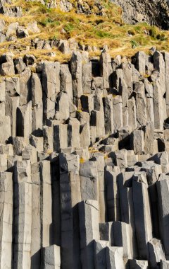 Gardar bazalt sütunları, İzlanda. Bir sürü büyük, pürüzlü kayaları olan kayalık bir uçurum. Kayalar, derinlik ve doku hissi yaratacak şekilde sıralanmış. Sahne dayanıklılık ve güçten oluşur.
