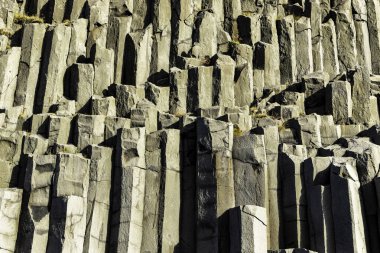 Gardar bazalt sütunları, İzlanda. Bir sürü farklı boyutta kayaları olan kayalık bir uçurum. Kayaların hepsi farklı şekil ve boyutlarda ve hepsi üst üste yığılmış. Sahne dayanıklılık ve güçten oluşur.