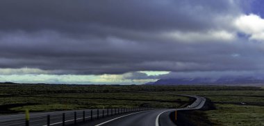 Ufukta yosunlu yosunlu merdivenler olan uzun, boş bir yol. Gökyüzü bulutlu ve güneş görünmüyor.