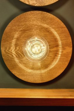 Üzerinde ampul olan ahşap bir tabak. Tabak yuvarlaktır ve ahşap bir kenarı vardır.
