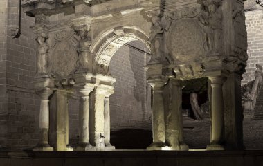 Baeza, İspanya 'daki Santa Maria yazı tipi. Kemer geceleri ışıldıyor, gizem ve entrika hissi yaratıyor. Işık, taş sütunları ve kemer yolunu aydınlatır. Başka bir dünyaya açılan bir kapıymış gibi gösterir.