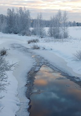 Gökyüzünün koyu renklerini yansıtan buzun kıyısı