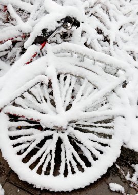 Snow covered wheel of an abandoned bicycle clipart