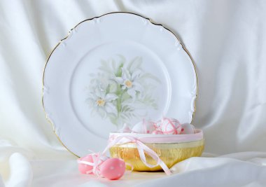 Beyaz arka planda güzel tabaklar ve pembe paskalya yumurtaları