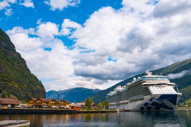 Flam / Norveç - 10.18.2022: Yolcu gemisi küçük bir kasabaya yanaştı. Fiordlarla, dağlarla ve okyanuslarla çevrili güzel bir doğa. Güneşli bir gün