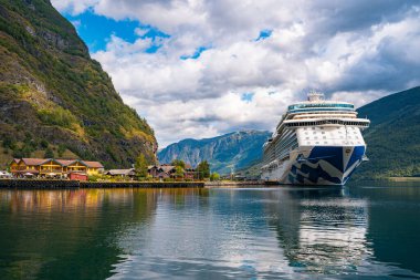 Flam / Norveç - 10.18.2022: Yolcu gemisi küçük bir kasabaya yanaştı. Fiordlarla, dağlarla ve okyanuslarla çevrili güzel bir doğa. Güneşli bir gün