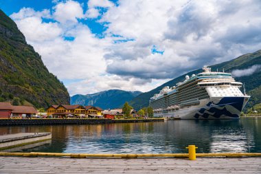 Flam / Norveç - 10.18.2022: Yolcu gemisi küçük bir kasabaya yanaştı. Fiordlarla, dağlarla ve okyanuslarla çevrili güzel bir doğa. Güneşli bir gün