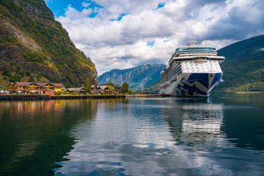 Flam / Norveç - 10.18.2022: Yolcu gemisi küçük bir kasabaya yanaştı. Fiordlarla, dağlarla ve okyanuslarla çevrili güzel bir doğa. Güneşli bir gün