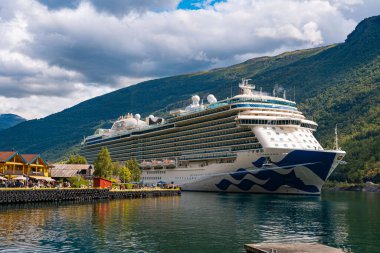 Flam / Norveç - 10.18.2022: Yolcu gemisi küçük bir kasabaya yanaştı. Fiordlarla, dağlarla ve okyanuslarla çevrili güzel bir doğa. Güneşli bir gün