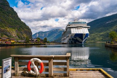 Flam / Norveç - 10.18.2022: Yolcu gemisi küçük bir kasabaya yanaştı. Fiordlarla, dağlarla ve okyanuslarla çevrili güzel bir doğa. Güneşli bir gün