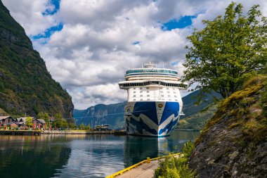 Flam / Norveç - 10.18.2022: Yolcu gemisi küçük bir kasabaya yanaştı. Fiordlarla, dağlarla ve okyanuslarla çevrili güzel bir doğa. Güneşli bir gün