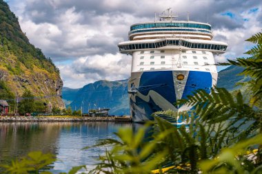 Flam / Norveç - 10.18.2022: Yolcu gemisi küçük bir kasabaya yanaştı. Fiordlarla, dağlarla ve okyanuslarla çevrili güzel bir doğa. Güneşli bir gün