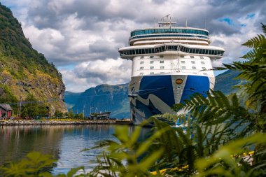 Flam / Norveç - 10.18.2022: Yolcu gemisi küçük bir kasabaya yanaştı. Fiordlarla, dağlarla ve okyanuslarla çevrili güzel bir doğa. Güneşli bir gün