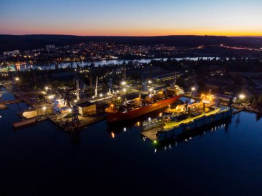 Tersanenin hava manzaralı kuru rıhtım bakım ve onarım kargo gemisi nakliyesi ve geceleri denizde petrol gemileri