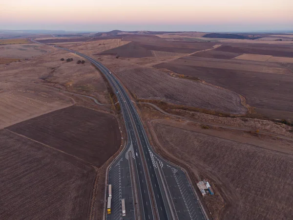 Aerial top view of highway road at sunset in autumn. Top view from drone of road